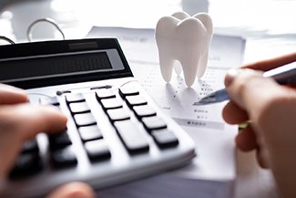 A patient calculating the cost of cosmetic dentistry
