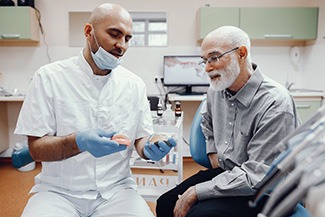 A dentist talking with a patient about dentures