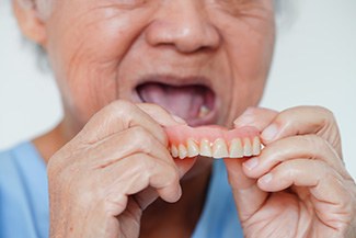 Senior taking out his dentures