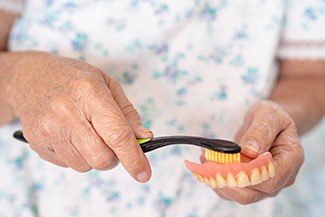 Woman brushing dentures
