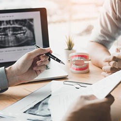 a dentist discussing dental implant treatment with a patient