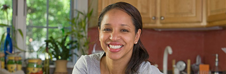 Woman in her kitchen smiling big