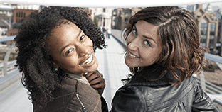 Two young women looking back smiling