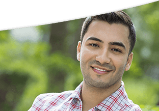 Young male wearing a plaid shirt and smiling