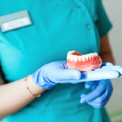 Denture dentist in Viera holding a denture model