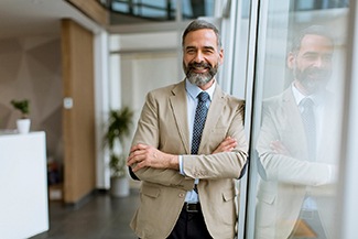 Man smiling at office building