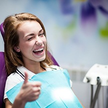 A dental patient giving a thumb-up.