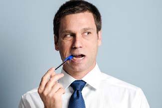 Man with dental implants in Melbourne, FL chewing on pen