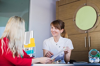 Woman and receptionist discuss financing for dental implants