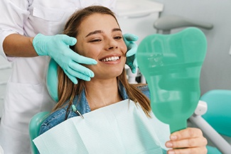 Woman with SureSmile in Melbourne smiling in mirror