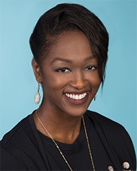 Female wearing black scrubs smiling