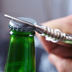 Person using bottle opener to open a beverage