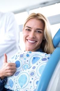 woman giving thumbs up in dental chair