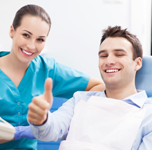 Man in dental chair giving thumbs up