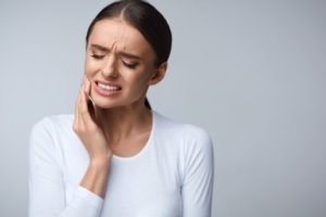 Woman with broken dental crown in pain