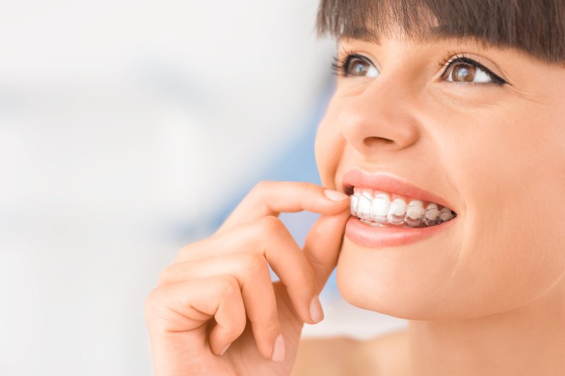 Female patient wearing Invisalign trays