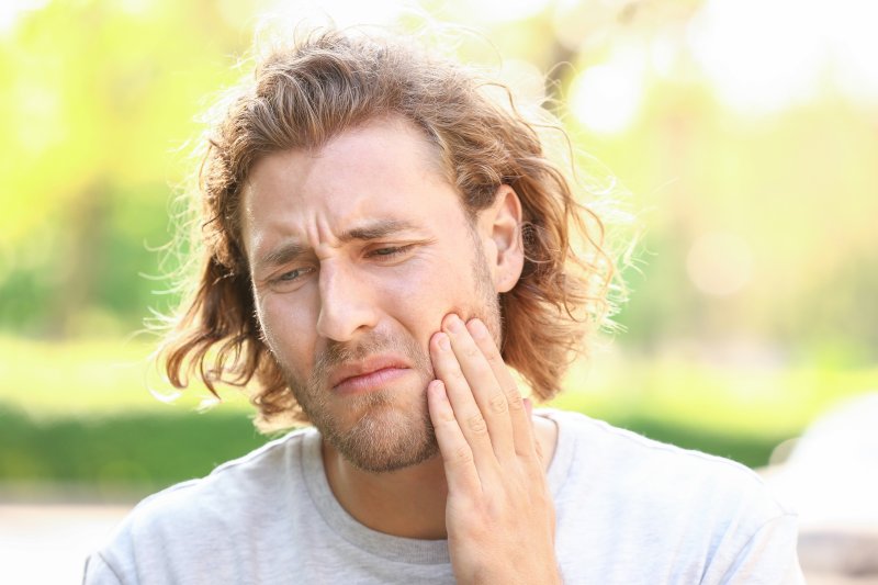 Closeup of young man suffering with toothache