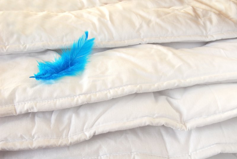White weighted blanket with a feather on top