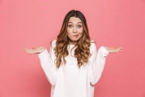 Woman shrugging after losing her dental filling.