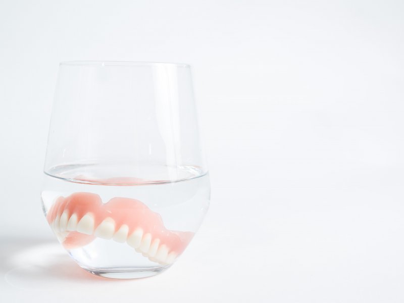 dentures soaking in a glass