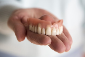 a closeup of someone holding a denture