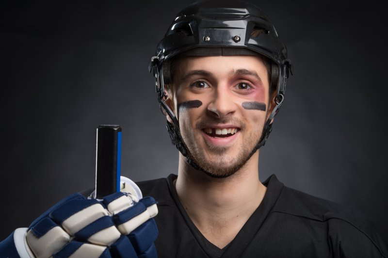 A hockey player with a missing tooth who is considering a dental implant