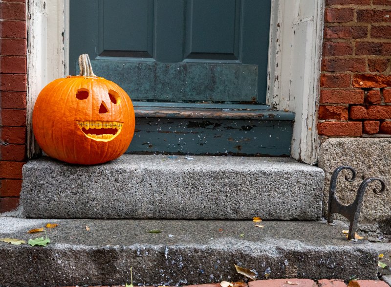 A pumpkin on a stoop smiling with good oral health