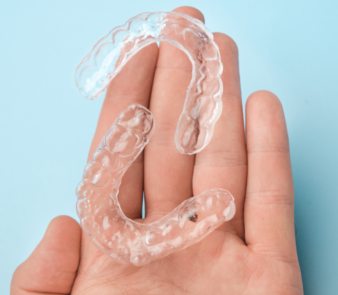 Hand holding clear aligners