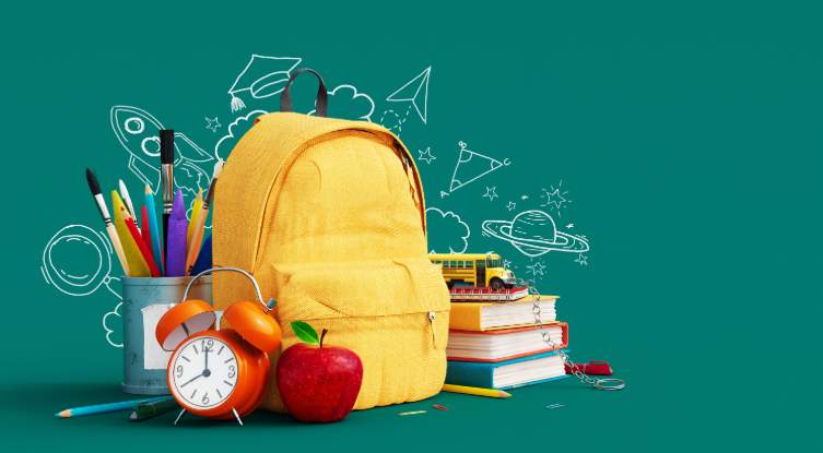 Yellow backpack with school supplies on a forest green background