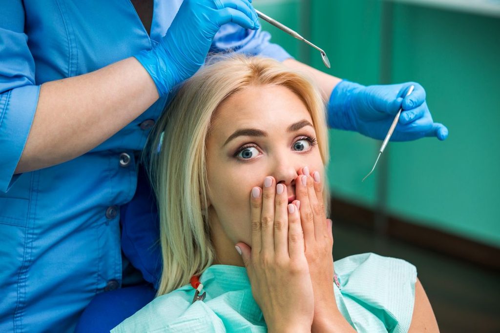 A woman hiding her mouth from a dentist